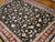 8' x 11'7" Chinese wool rug displayed on parquet floor, black field with burgundy floral border