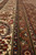 Multiple guard borders in ivory, camel and slate blue seen along the rug edge