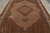 Close overhead of taupe brown field, allover Herati lattice and camel corner spandrels