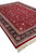 8 by 12 red Oriental rug viewed from the side with ivory fringe and vine pattern
