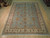 9 x 12 Pakistani Oushak rug photographed lengthwise, all-over floral field framed by wide cream border