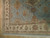Close-up corner showing ivory palmette border, rust guard stripes and hand-knotted wool pile against teal field