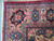 Corner detail with ivory border rosettes, navy cartouches and pink floral vinework on the Tabriz rug
