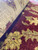 Made in India wool rug rolled back to show plush pile depth and even weave