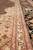Border close-up with red outlines, paisley guard band and beige spandrel flowers on wool pile
