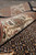 Rolled edge of the wool and silk rug showing pile depth and ivory border flowers