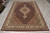 Hand-knotted wool and silk Mahi rug shown full length with cream fringe in showroom