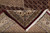 Folded corner reveals cotton foundation, burgundy selvage and the hand knotted back of rug