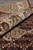 Rolled corner showing ivory border pile depth beside the burgundy herati patterned field