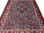 9x12 Persian Bakhtiar rug photographed at an angle, showing rows of blue and red garden compartments