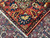 Folded corner showing hand-tied ivory fringe, tight selvage and vivid red border palmette