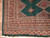 Corner detail with green outer edge, ivory guard borders and cream fringe on tile flooring