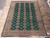 8'3" x 11' Pakistani wool rug photographed flat on travertine tile showing complete lattice field and borders