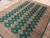 Angled floor view highlighting the plush wool pile and stepped ivory diamonds across the green field