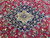 Navy medallion with sky blue pendants floating on the burgundy floral field, hand-knotted wool pile