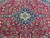 Symmetrical floral field around the navy medallion, showing scrolling vines, ivory blossoms and green leaves