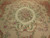 Close view of ivory field, oval floral medallion, sage leaf garlands and ribbon scrollwork stitching