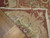 Folded corner revealing reverse side and cotton binding tape of this 9x12 flat woven needlepoint rug