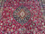 Field and medallion view with turquoise accents, boteh paisleys and leafy vines on burgundy