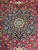 Close-up of the navy eight point star medallion with light blue, coral and ivory floral detail