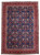 8'1" x 11' Persian Tabriz rug photographed flat, navy field, ivory vine lattice, red floral border