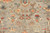 Close-up of fine wool pile with coral lotus blossoms, teal diamonds and ivory vine scrollwork