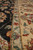 Camel gold main border detail with red flower heads, green leaves and dark outline stripe