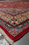 Low angle along the red selvedge showing ivory fringe and layered floral guard bands