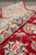 Rolled edge showing thick fine wool pile depth and beige border scrolls on this rug