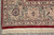 Ivory border corner detail with navy palmettes, green leaves, red guard stripes and fringe