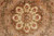 Close up of a single 8 petal rosette roundel in cream, rust and sage green