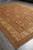 Perspective shot of the Peshawar wool rug showing ivory border and warm salmon brown field