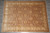 Warm blush and beige hand-knotted wool rug photographed flat on grey slate studio flooring