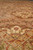 Low angle detail of dense wool pile with rust flowerheads and green vine scrollwork