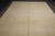 Reverse side of the wool rug showing pale ivory back and faint storage fold lines