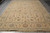 Warm golden beige Ziegler Chobi wool rug photographed flat on grey tile showing sage green border
