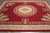 Overhead view of flat weave wool rug showing laurel wreaths and cream rose outer border
