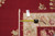 Tape measure and inventory tag laid across the ivory border and burgundy field