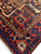 Corner and border detail with red main border, ivory vine guard stripe and brown cartouche panels