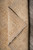 Folded back corner revealing tight hand-knotted cotton foundation beneath the natural undyed wool pile