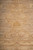 Macro view of a golden palmette motif dissolving into the softly variegated beige ground