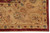 Corner detail of the camel gold border with vine scrolls, teal rosettes and rust outlines