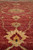 Macro pile shot of silky wool showing subtle abrash in the burgundy field and gold blossoms