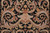 Detail of the central acanthus crest in caramel and ivory wool against deep black ground