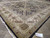 9 x 12 hand-knotted wool rug seen at an angle, ivory border palmettes catching the light