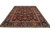 Traditional Oriental rug angled view showing indigo blue border and burgundy floral field