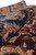 8 x 11 wool rug rolled to show pile depth, indigo border and rust palmettes