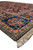 Side angle of Oriental wool rug corner, sapphire border medallion above braided ivory fringe