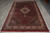 6'6" x 10'1" wool and silk Mahi rug lying flat on grey tile warehouse floor
