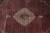 Close up of the lobed ivory medallion and pendants set against deep pom red field